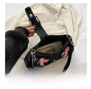 Black canvas underarm bag with pink gothic cross embroidery and silver chain details