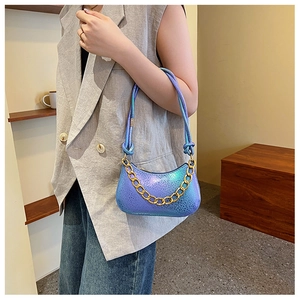 Close-up of laser holographic blue-purple hobo bag with gold chain and lizard pattern