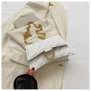 Detail of white V-quilted faux leather bag with gold D-ring buckle and fine chain strap