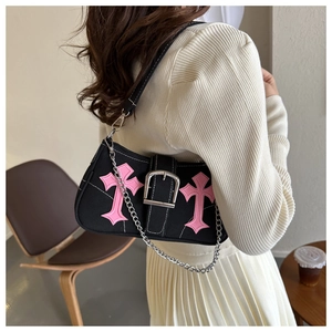 Chic black baguette bag with pink cross embroidery and silver chain on model shoulder