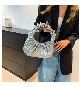 Detailed view of metallic silver pleated cloud bag with soft faux leather texture and handle