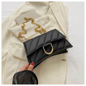 Detail of black quilted leather shoulder bag with golden D-shaped buckle and chain strap