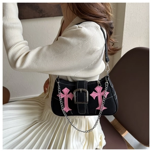 Detail of black gothic shoulder bag with pink cross embroidery and silver chain