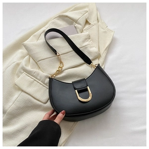 Détail du sac demi-lune en cuir noir avec boucle dorée en D et bandoulière en chaîne