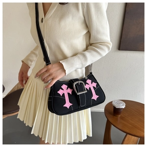 Detailed view of black underarm bag with pink cross patches and silver metal buckle