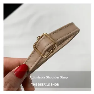 Close-up of beige adjustable PU leather strap with golden square metal buckle and stitching