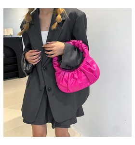 Detail view of pink pleated cloud bag on model showing soft PU leather texture