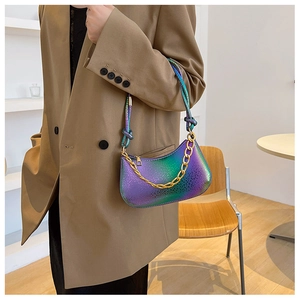 Close-up of a gradient iridescent chain bag featuring embossed scale texture and gold strap