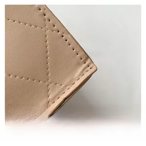 Detailed macro view of diamond quilted stitching on beige faux leather handbag fabric