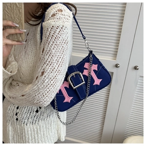 Detail of navy canvas underarm bag with pink gothic crosses and silver metal buckle