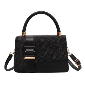 Black glitter handbag with gold buckle and adjustable strap on a clean white background