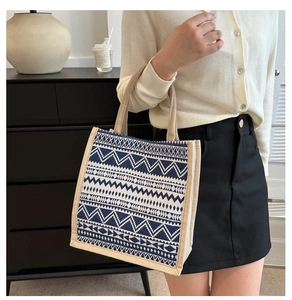 Close-up of linen tote bag featuring ethnic blue geometric patterns and durable handles