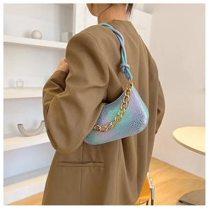 Close-up of holographic snake pattern shoulder bag with a stylish gold chain strap