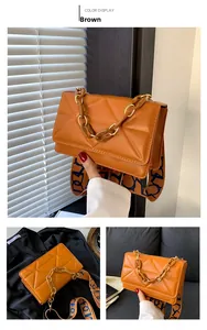 Close-up of quilted rhombic pattern brown bag with mixed metal and amber chain strap