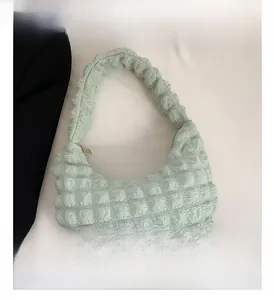Vista dettagliata della trama a bolle verde menta su una borsa hobo a pieghe