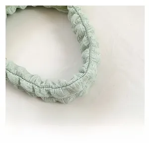 Dettaglio della tracolla verde chiaro con trama a bolle su borsa retrò chic