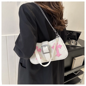 Detail of Y2K baguette bag featuring pink leather cross applique and silver chain strap
