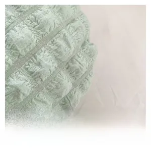 Dettaglio macro della texture arricciata e del tessuto verde menta della borsa a pieghe