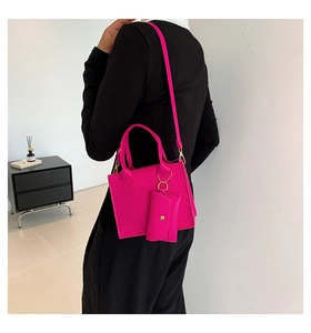 Detail of rose pink quilted crossbody bag with matching mini pouch charm on model