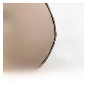 Macro shot showing premium leather texture and precise edge stitching of the shoulder bag