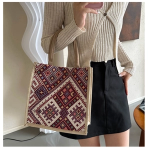 Ethnic style tote bag featuring intricate geometric woven patterns and khaki carry handles