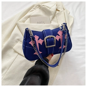 Detail of navy canvas underarm bag with pink cross embroidery and bold silver buckle