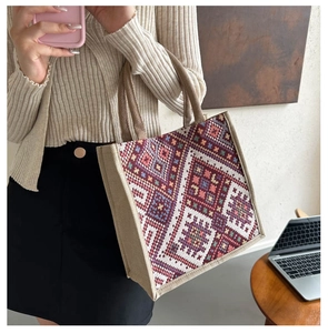 Close-up of ethnic geometric pattern embroidery on large canvas tote bag with dual handles
