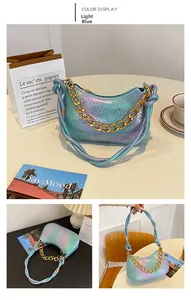 Detail of light blue laser handbag with gold chain strap and textured scale surface