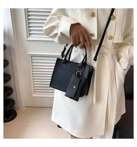 Detail view of black quilted crossbody bag with gold hardware and small matching pouch