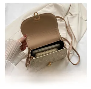 Detail showing internal capacity of the floral straw saddle bag with phone and wallet
