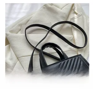 Close-up of V-shaped quilted stitching on a black tote bag with sturdy handles
