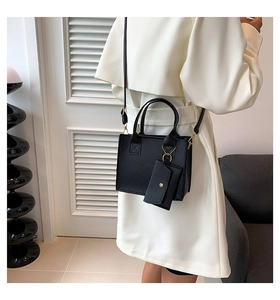 Quilted black handbag with matching mini purse and gold hardware shown on model