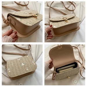 Detail of straw crossbody bag with floral embroidery and interior phone storage capacity