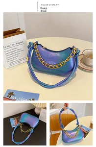 Detail view of a gradient dark blue snake-texture shoulder bag with a thick gold chain