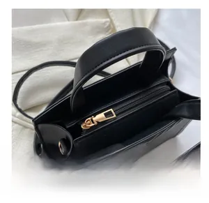 Close-up of smooth metal zipper and inner compartment on black crossbody bag