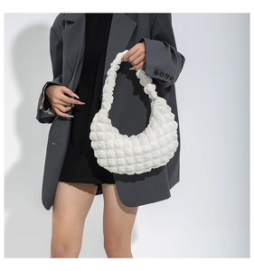 White ruched croissant shoulder bag with bubble texture on a grey oversized blazer