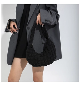 Detail of black quilted half-moon shoulder bag showing unique bubble texture and soft handle