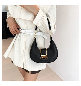 Close-up of a black hobo shoulder bag featuring gold hardware and a sleek leather finish
