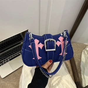 Blue canvas baguette bag with pink cross patches and silver buckle shown in life scene