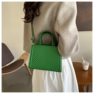 Detail of bright green chevron-quilted tote bag featuring high-quality faux leather texture