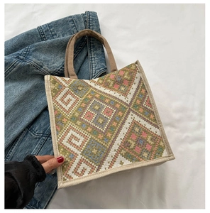 Detail of woven tote bag featuring colorful geometric patterns and durable webbing handles