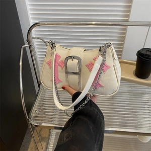 Cream canvas bag with pink crosses and silver chain strap shown in lifestyle view