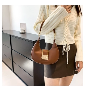 Detail showing brown hobo bag texture and polished gold rectangle metal lock buckle