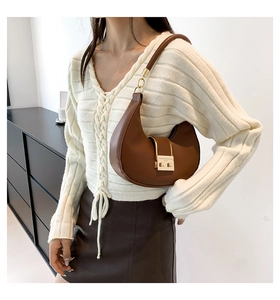 Brown leather half-moon shoulder bag featuring a polished gold metallic buckle detail