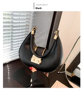 Close-up of black crescent shoulder bag with golden hardware and matte leather finish