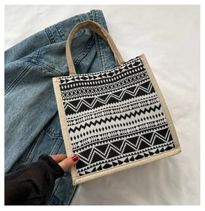 Detail of woven geometric pattern tote bag with rustic jute handles on denim fabric