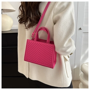 Detail of hot pink chevron quilted handbag with adjustable strap and gold hardware
