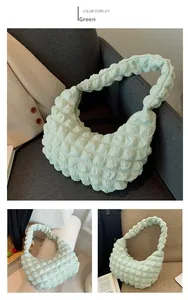 Close-up of green hobo bag with unique puffy texture fabric and stylish moon shape design