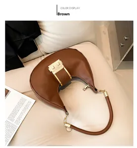 Detail of brown hobo bag with gold metal clasp on soft sofa, minimalist autumn style