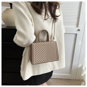 Detailed view of the chevron quilted texture and sturdy handles on the tote bag
